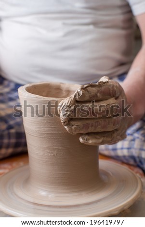 Hands of a potter, creating an earthen jar on the circle