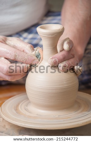 Hands of a potter, creating an earthen jar on the circle