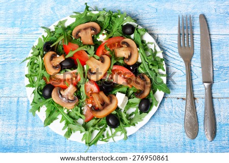 healthy salad of arugula, cheese, tomato, mushrooms and olives
