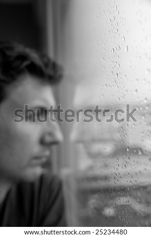 Loneliness or boredom, depression. Focus on the rain drops to leave the subject vaguely staring outside, with nothing to do.