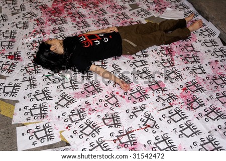HONG KONG, CHINA - 4 JUNE 2009. One young woman stages herself as a dead person in Hong Kong, China, to remember the fallen in Beijing\'s Tienanmen Square crackdown in 1989.