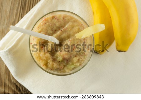 Shot of banana and celery smoothie with berries on wooden table horizontal top view