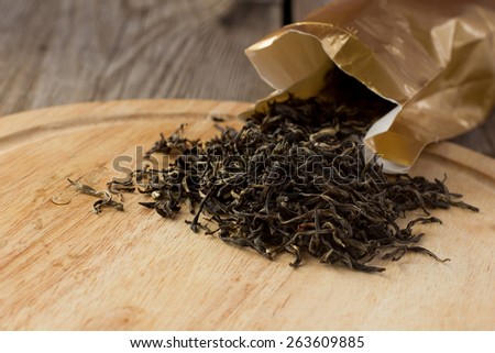 Shot of dry white tea leaves on wooden plate horizontal