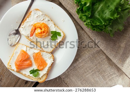 Wheat bread toasts with cream cheese, smoked salmon and shrimp selective focus horizontal top view