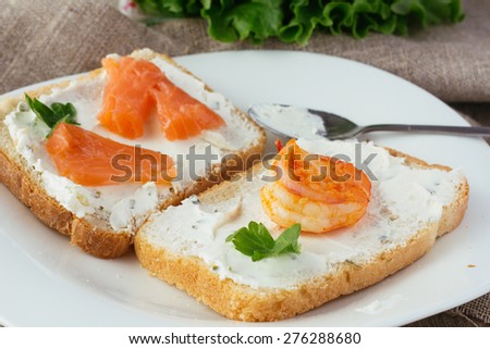 Wheat bread toasts with cream cheese, smoked salmon and shrimp selective focus horizontal
