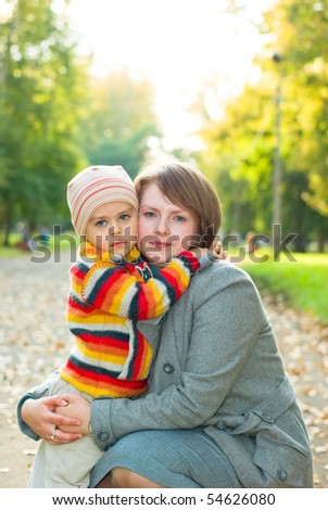 Mama hugs her son sad, autumnal park