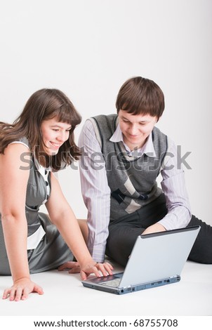 The man and the woman together work behind the laptop