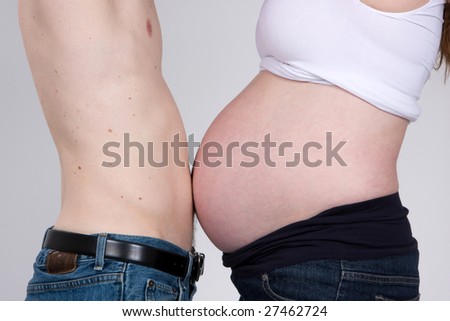 A man touches his stomach to his pregnant wife\'s  stomach.