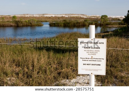 A posted sign marks an area roped off from public access for a protected bird site in Destin, Florida.