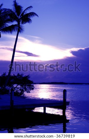 The sun sets behind a cloud bank in this tropical sunset on a Florida Keys island.