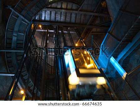 Moving elevator inside shaft with staircase.