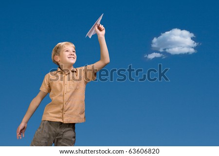 The nine-year boy starts the paper plane against the sky