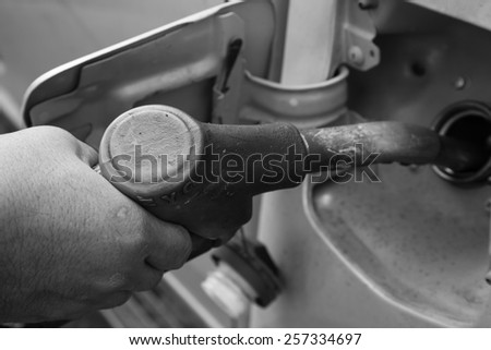 Close up of a mans hand refilling the car with a gas pump