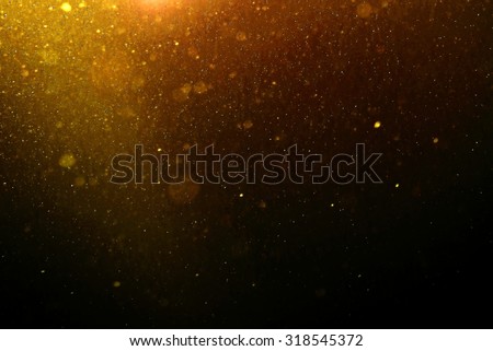 Abstract gold background with floating and reflecting dust blur