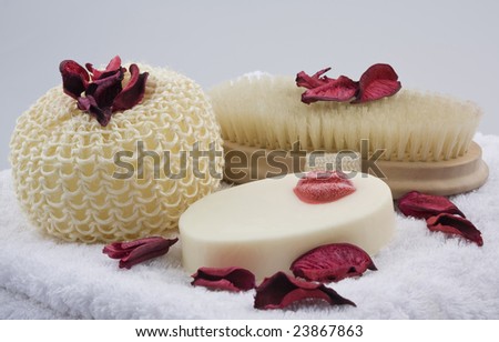 Bath product arrangement on white towel decorated with red dry flowers