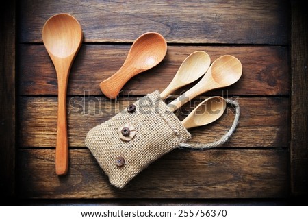 wood  spoon in small bag on wood  background dark brown.