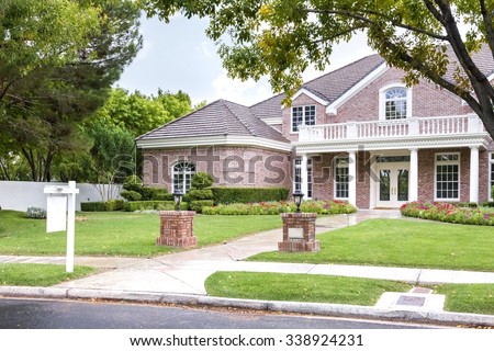 Front Yard Of Upscale Suburban House with a blank for sale sign