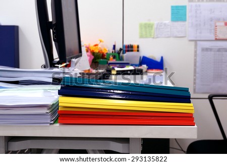 Stack of document and plastic ridge folders including  blue, yellow, red, and green color on the table to be used for training.
