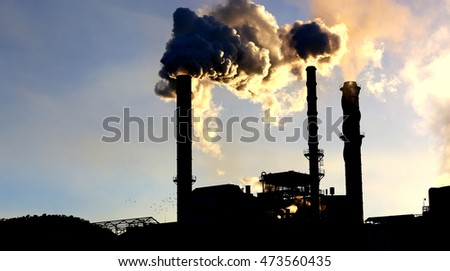 Stacks billowing smoke into blue skies.Industrial mine sites .Mine stacks or sugar cane mills and steam stacks. Smokestacks