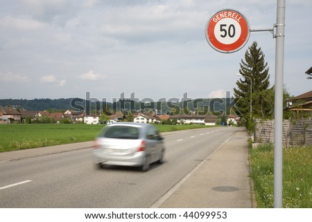 Speed limit at the village entrance and racing cars.