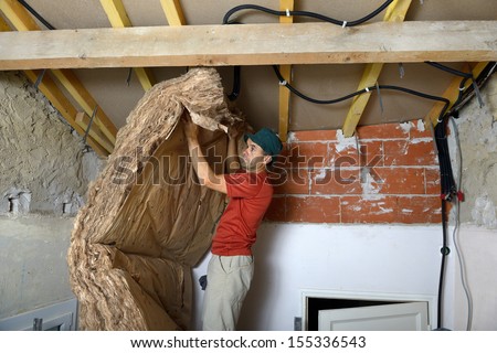 A Worker Who Insert The Ceiling Insulation