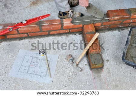 construction of a brick wall by a bricklayer