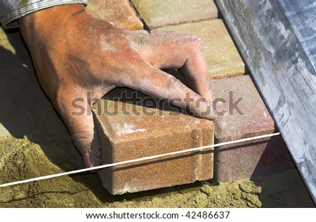 worker puts sidewalk tile