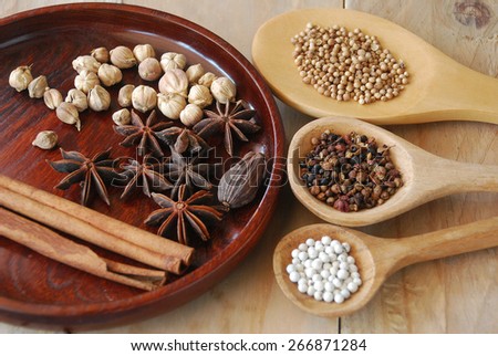 various spices for chinese food boiled decorate on ladle round tray and wooden background