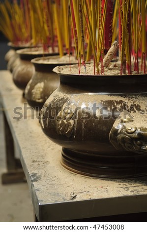 Urns in a Buddhist temple filled with incense and larger prayer sticks - Saigon Vietnam