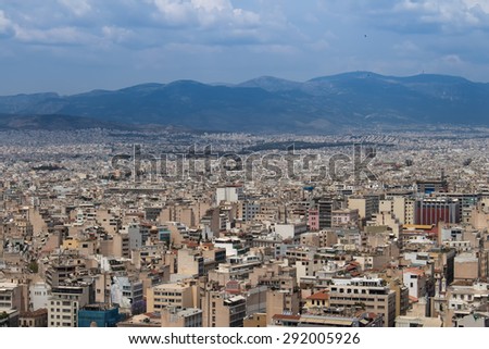 Athens City View, Greece\
View on Athens, Greece from Acropolis. Mountains lining the city in the background. Cloudy sky.