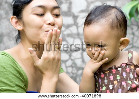 mother teach her baby girl a goodbye kiss