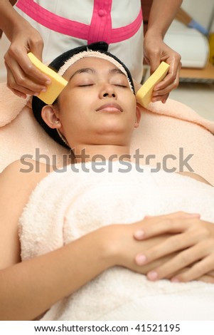 pretty asian young woman having facial treatment at beauty clinic