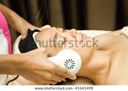 collagen serum being applied on young woman face during facial treatment at beauty clinic