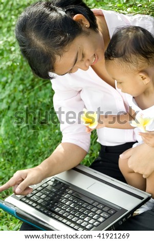 asian career woman give knowledge of a computer to baby girl