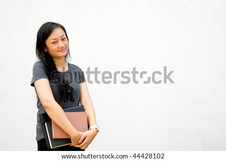asian female student holding books on a white background