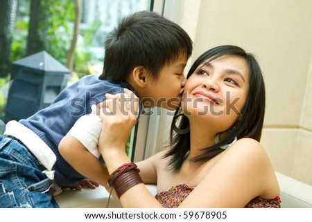 asian ethnic boy kiss his happy mother