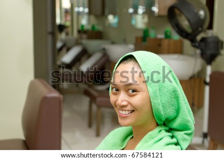 Happy asian ethnic young woman at hairdressing salon