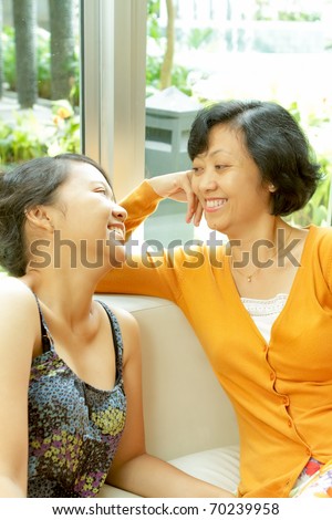 Family portrait of Asian ethnic mature mother enjoy talking with teen daughter