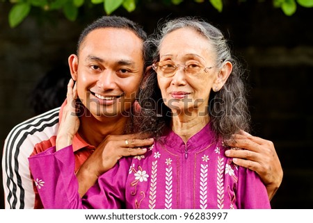 family portrait of asian ethnic senior woman with young adult son