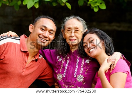 family portrait of asian ethnic senior woman with young adult son and daughter