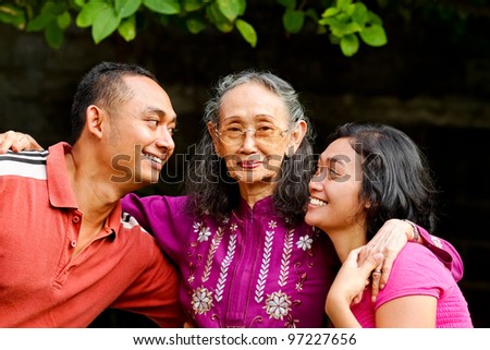 family portrait of asian ethnic senior woman with young adult son and daughter