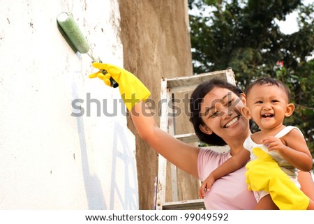 asian ethnic mother happy painting house together with child