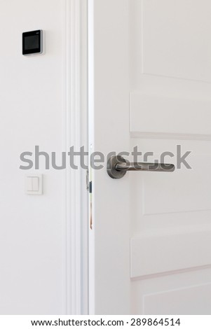 Open white door with metallic handle