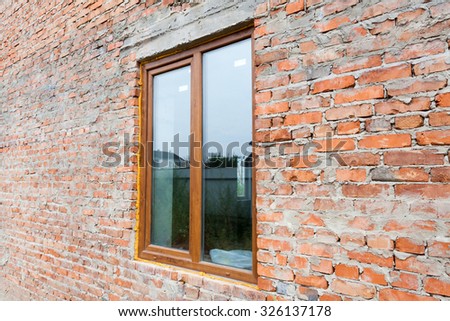 Single plastic window on a wall with red bricks. nstall window against brick wall facade.
