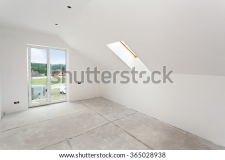 Attic room under construction with gypsum plaster boards and windows
