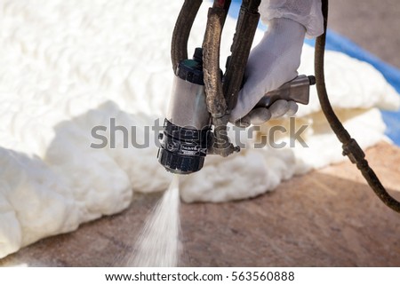 Technician spraying foam insulation using Plural Component Spray Gun
