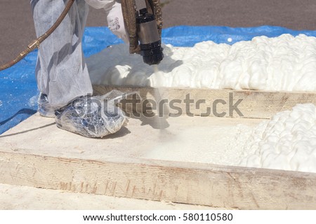 Technician spraying foam insulation using Plural Component Spray Gun
