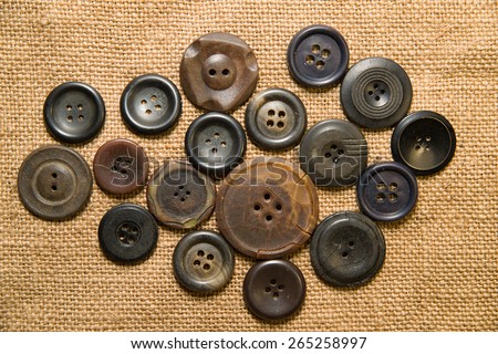 A lot of old buttons scattered on the old cloth