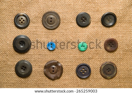 A lot of old buttons scattered on the old cloth