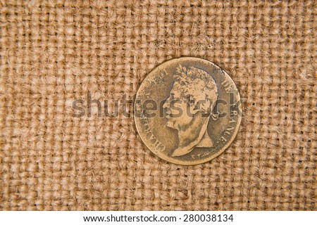 A lot of old bronze coin with portrait of king on the old cloth